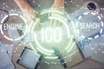 Double exposure of man's hands typing over computer keyboard and crypto currency theme hologram drawing. Top view. Blockchain concept.