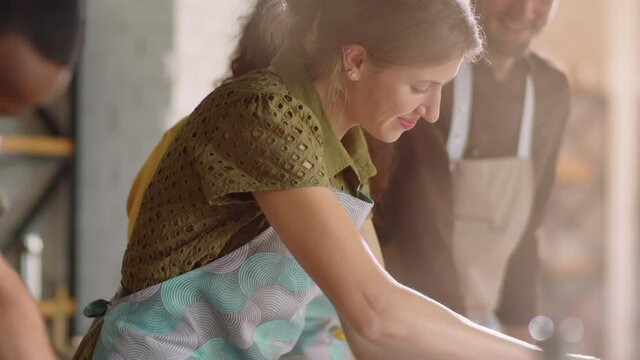 Tilt up shot of positive woman in apron grating cheese while learning how to prepare food during cooking master class