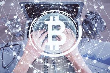 Double exposure of man's hands typing over computer keyboard and crypto currency theme hologram drawing. Top view. Blockchain concept.