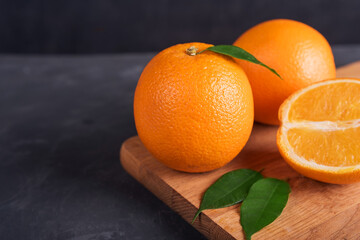 Fresh orange fruit with leaves on wooden table