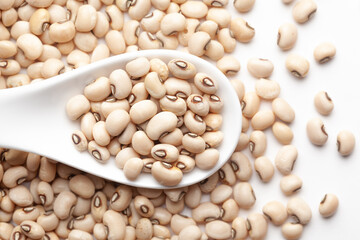 macro Close-up of Organic soybean,  (Glycine max ) or soya bean dal on a white ceramic soup spoon....