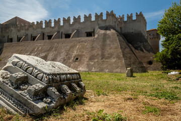 View of the ancient castle of Santa Severa from inside the historical citadel , in the foreground an ancient marble decoration , Santa Severa , Rome , Italy