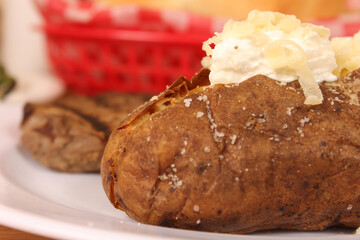 Sirloin Steak With Baked Potato and fresh rolls in background Shallow DOF
