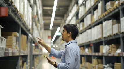 Man worker checking products with tablet in warehouse.