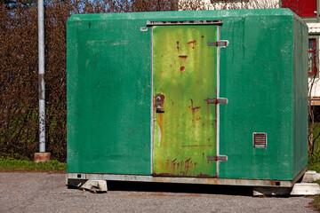 a green temporary toilet in the parking lot