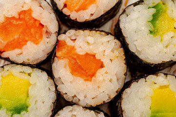 Rolls with salmon, cucumber and avocado.