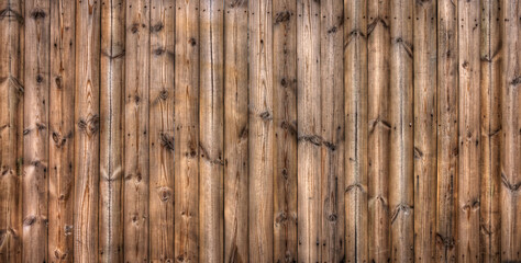 Wooden planks fence. It made of wood lumbers or timbers.