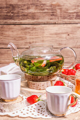 Teatime concept with aromatic mint tea, ripe strawberries, sweet honey