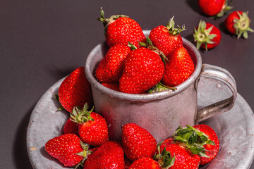 Concept of summer food with a strawberry on a black stone background