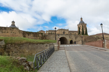 Fototapeta na wymiar Majestic front view at the fortress gate and iconic spanish Romanesque architecture building at the Cuidad Rodrigo cathedral, towers and domes, downtown city