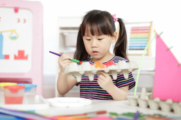 young girl hand making boat craft using egg cartons  for homeschooling