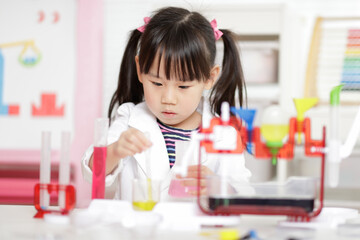 young girl plays colour mixing science experiment for home schooling
