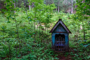 Fototapeta na wymiar nice old wayside shrine in the green forest