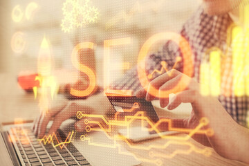 Double exposure of man hands holding a credit card and SEO drawing. Search engine optimization in...