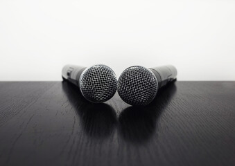 two microphone on a white background. microphone lying on a black table with a white background. concept sound speaker.