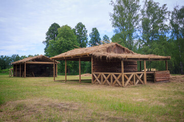 Empty wooden stables for storing hay and grazing horses, located in the middle of a field against...