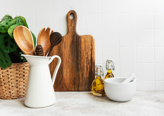 Kitchen utensils, tools and dishware on on the background white tile wall.