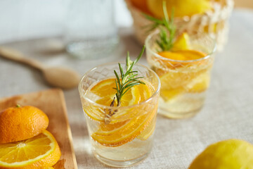 Citrus and rosemary fresh lemonade in glass on a white table at home