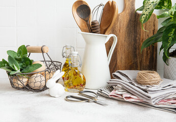 Kitchen utensils, tools and dishware on on the background white tile wall.
