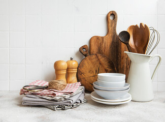 Kitchen utensils, tools and dishware on on the background white tile wall.
