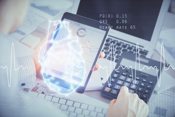 Double exposure of man's hands holding and using a phone and heart drawing. Medical education concept.