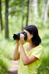 Portrait of a woman photographer covering her face with the camera