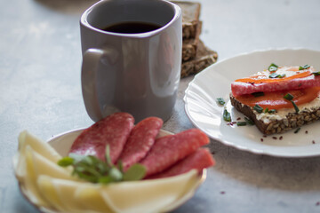 Cooked breakfast with coffee and sandwich. All this on a gray background