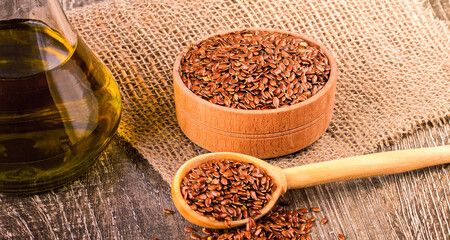 Brown flax seeds and flaxseed oil on a wooden surface