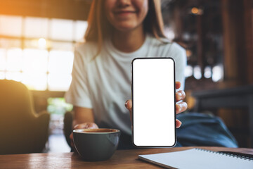Mockup image of a beautiful woman showing a mobile phone with blank white screen