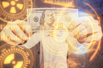 Multi exposure of Tech drawing hologram and USA dollars bills and man hands. Technology concept.