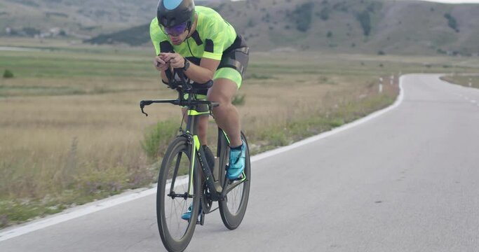 Triathlon sportsman athlete cyclist riding professional racing bicycle.