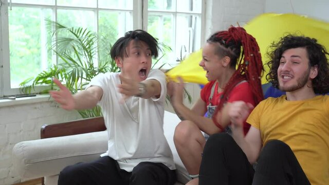 Colombian football fans watch TV at home. Emotional sports fans with Colombia flag
