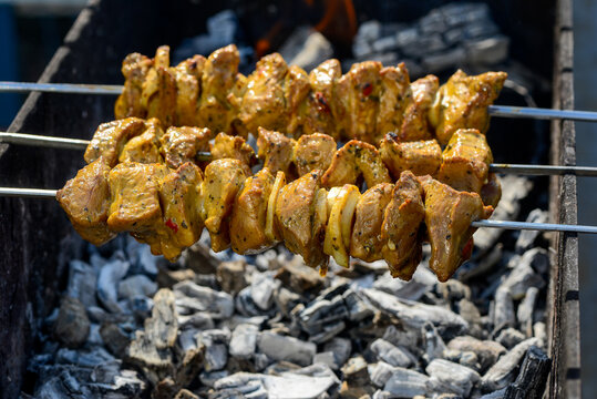 pork kebabs on skewers to grill on mongala with coals
