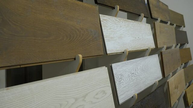 Samples of laminate on a stand of different wood textures in a flooring store
