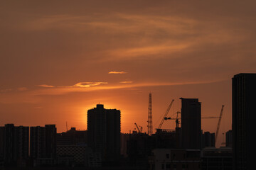 Fototapeta na wymiar sunset over the city skyscape crane on building