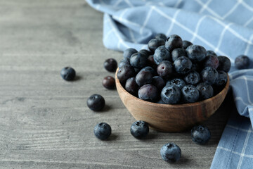 Bowl of fresh blueberry on gray textured background
