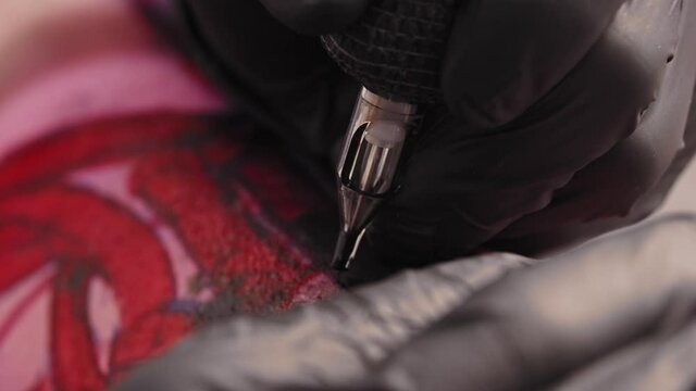 Tattoo session - tattooing the letters over red sketch