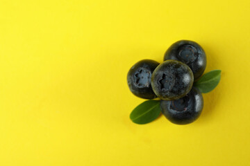 Fresh blueberry with leaves on yellow background