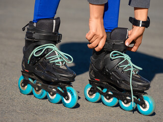 Close-up of an Anonymous Woman's Hands Fixing Laces on Roller Blades Before Skating.