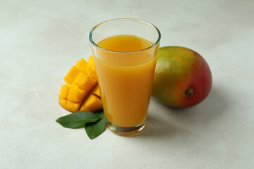 Ripe mango fruit and juice on white textured table