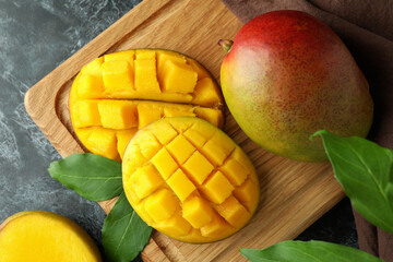Tasty ripe mango fruit on black smokey table