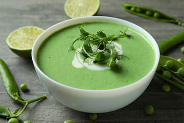 Concept of tasty eating with pea soup on gray textured table