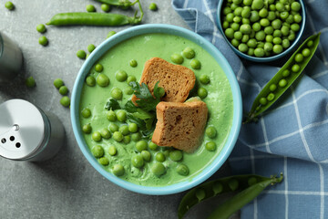 Concept of tasty eating with pea soup on gray textured table