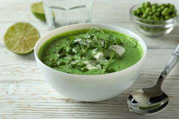 Concept of tasty eating with pea soup on white wooden table