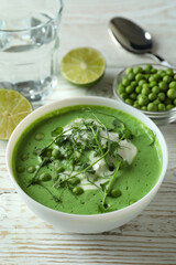 Concept of tasty eating with pea soup on white wooden table