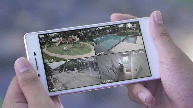 close up of back view using home security camera system on mobile outside.