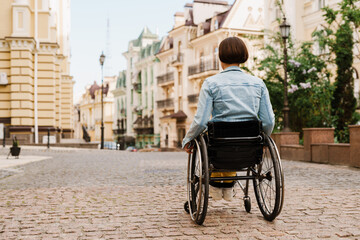 Brunette woman sitting in wheelchair on city street