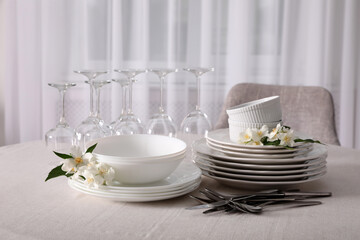 Set of clean dishware, cutlery and wine glasses on table indoors