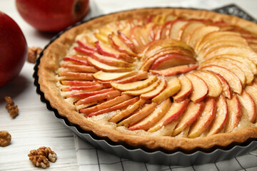 Delicious homemade apple tart on white wooden table, closeup