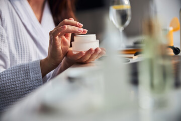 Focused photo on cream that being in female hands